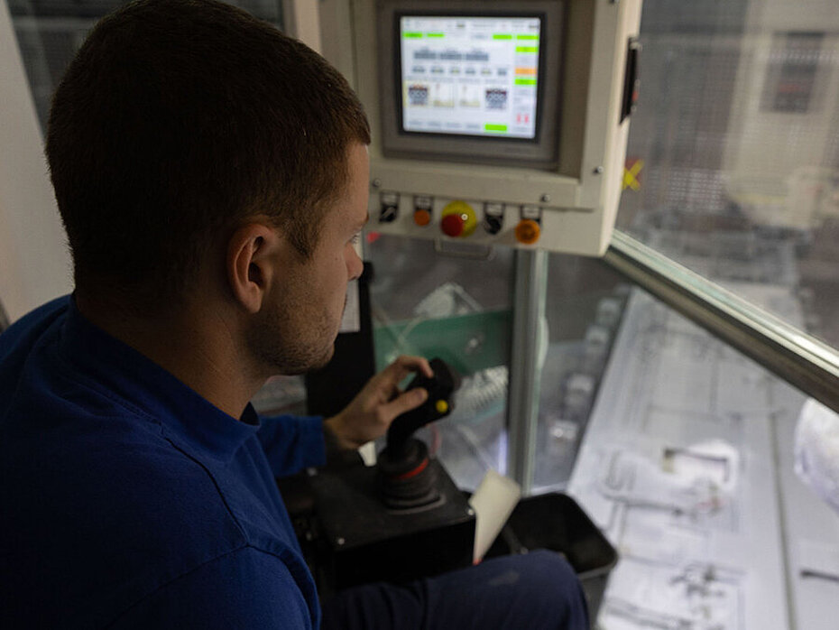 Employé opérant une machine de service d’électrolyse dans une usine de production d’aluminium